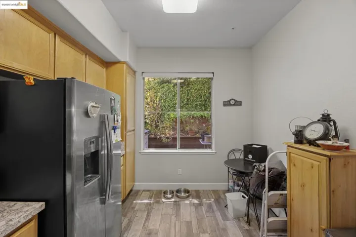Kitchen featuring stainless steel fridge, light wood-style flooring, and light brown cabinetry