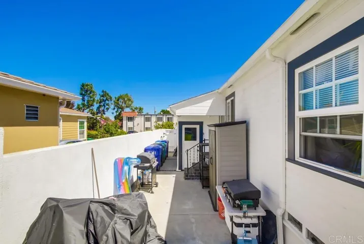 View from backyard down the side yard to side yard gate, the garage and another entry into the home