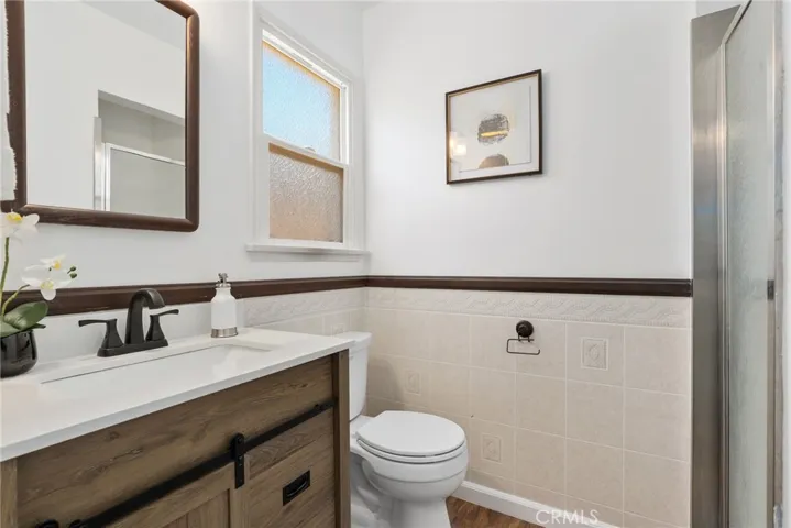 Primary bathroom with updated vanity and white tiled shower.
