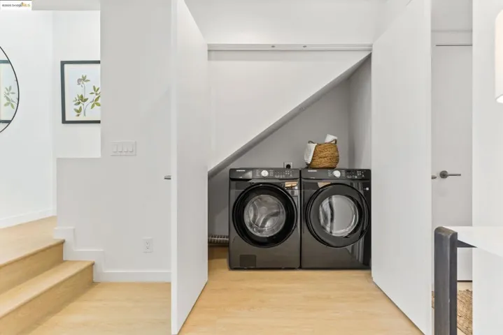 Laundry area featuring wood finished floors and washing machine and dryer
