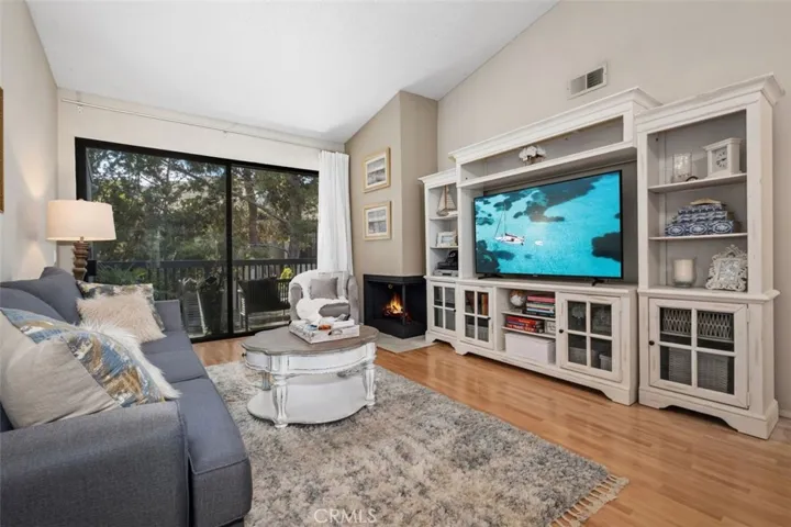 Living room with fireplace and views of nature out of the back patio.