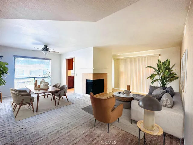 Large living/dining room with central focal fireplace. Lots of windows