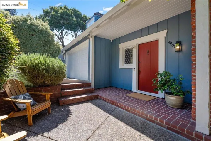 View of exterior entry with board and batten siding and a patio