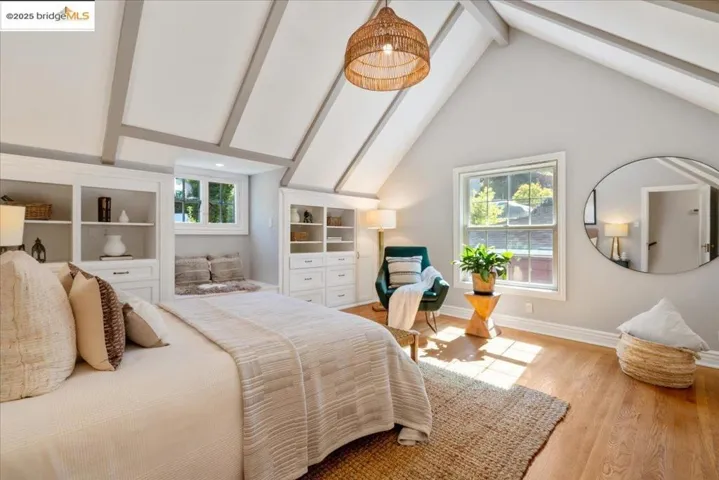 Bedroom featuring beam ceiling, light wood-style floors, and high vaulted ceiling