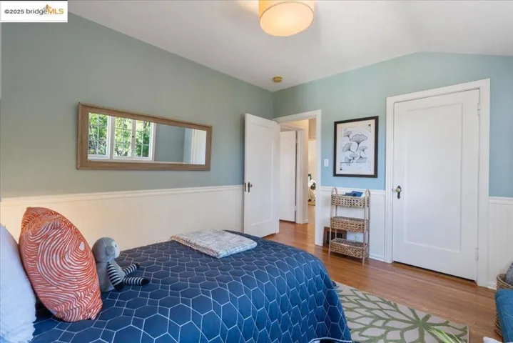 Bedroom with a wainscoted wall and wood finished floors