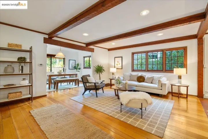 Living area featuring beam ceiling, light wood-style flooring, and recessed lighting