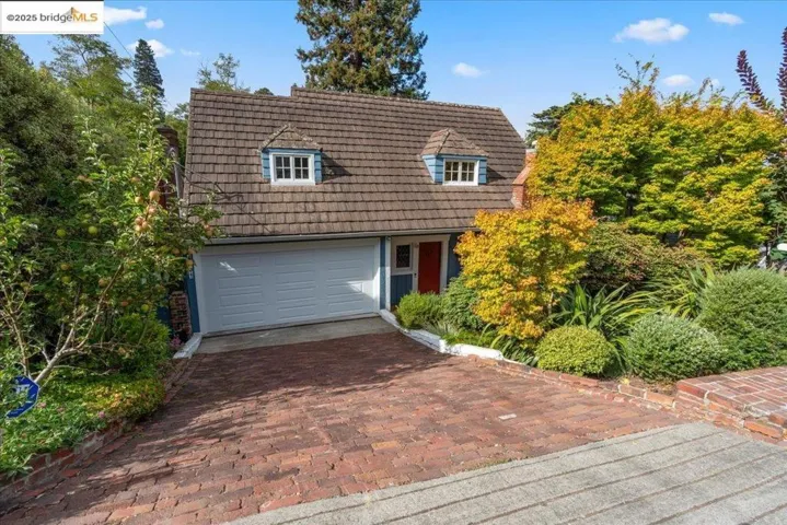 View of front of home with decorative driveway and a garage