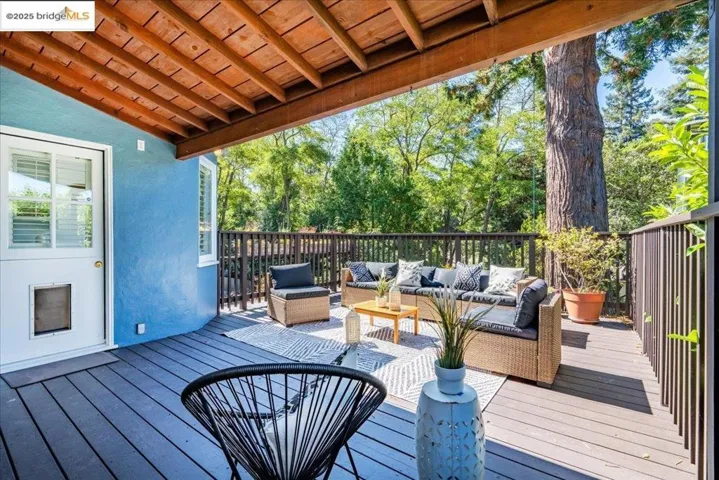 Wooden deck with an outdoor hangout area and view of scattered trees