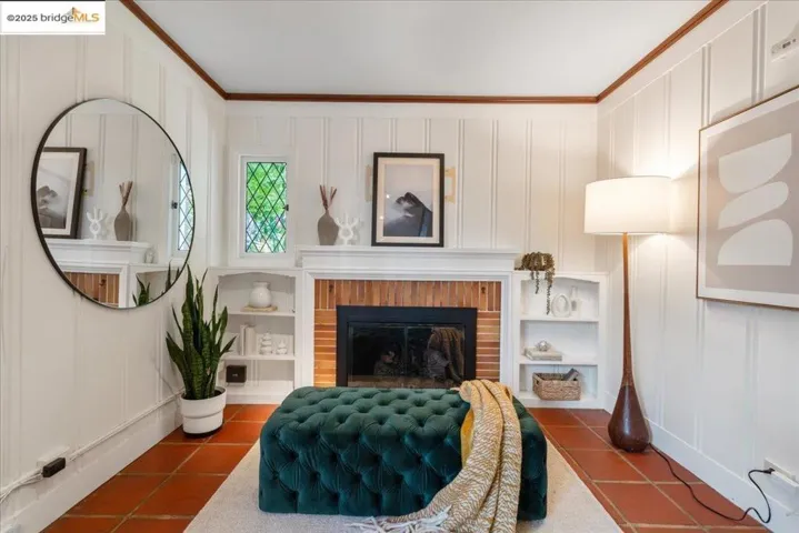 Sitting room featuring a decorative wall, ornamental molding, dark tile patterned floors, and a fireplace