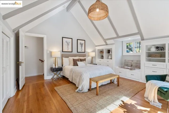 Bedroom featuring beam ceiling, high vaulted ceiling, and light wood finished floors