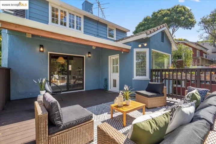 Rear view of property featuring an outdoor hangout area, a deck, stucco siding, and a chimney