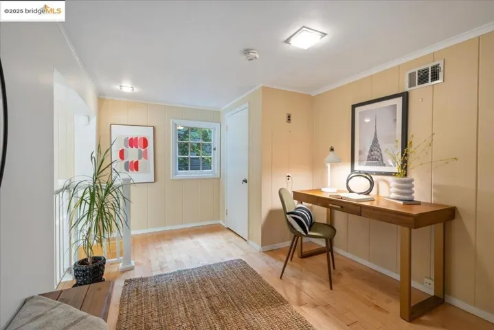 Office space featuring ornamental molding and light wood-style flooring