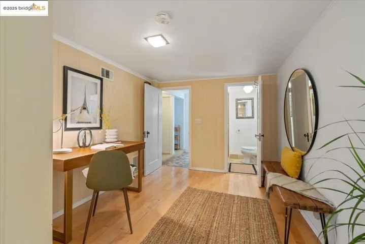 Home office featuring light wood finished floors and ornamental molding