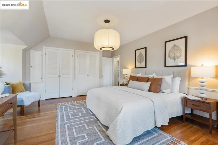Bedroom with multiple closets and light wood-type flooring