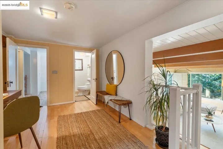 Hallway with light wood-type flooring and crown molding