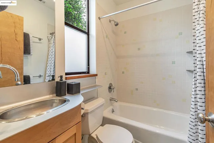 Full bath with shower / tub combo with curtain and vanity