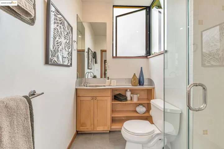 Bathroom featuring light tile patterned floors, a shower stall, and vanity