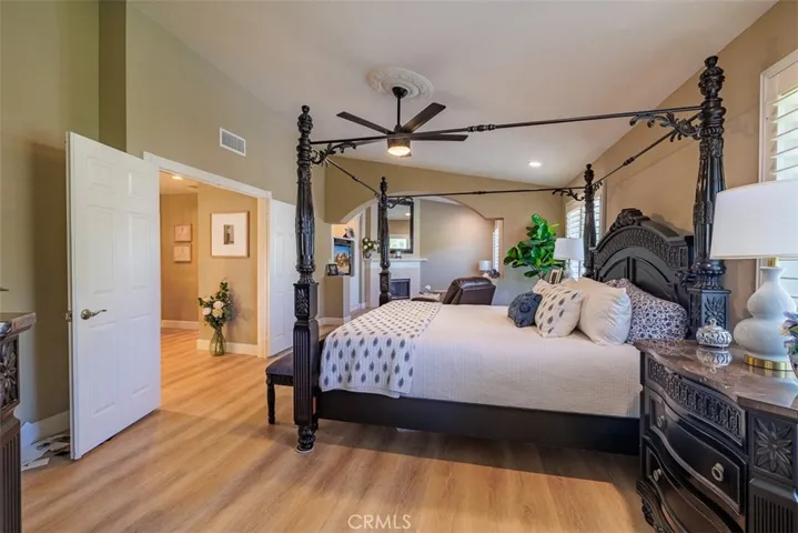 Primary suite features a large retreat with a fireplace, vaulted ceilings, plantation shutters, recessed lighting