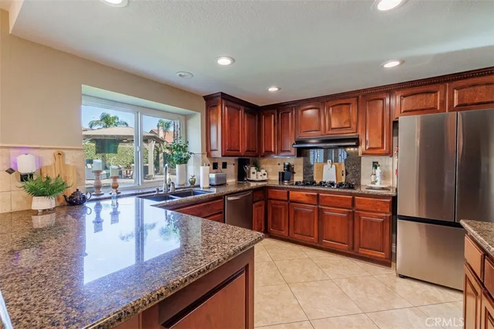 Remodeled kitchen has granite counters, custom cabinetry with lots of storage, added recessed lighting, and walk-in pantry