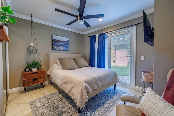 Downstairs bedroom with ceiling fan and sliding door into the backyard