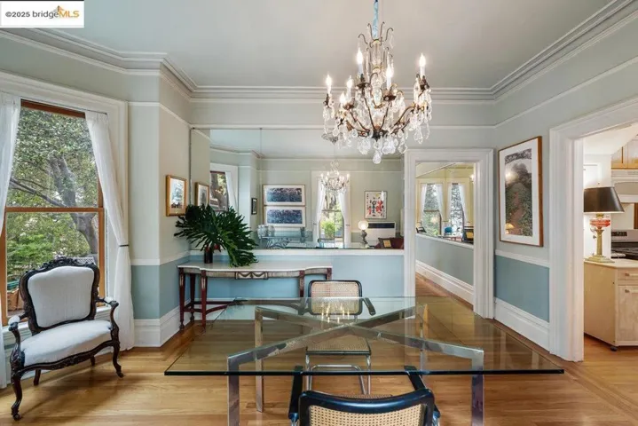 Living area with a chandelier, ornamental molding, and wood finished floors
