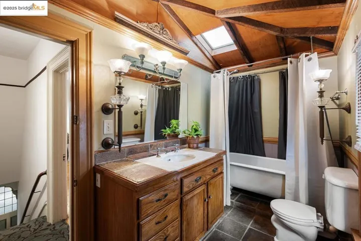 Bathroom with a skylight, vanity, lofted ceiling, and wood ceiling