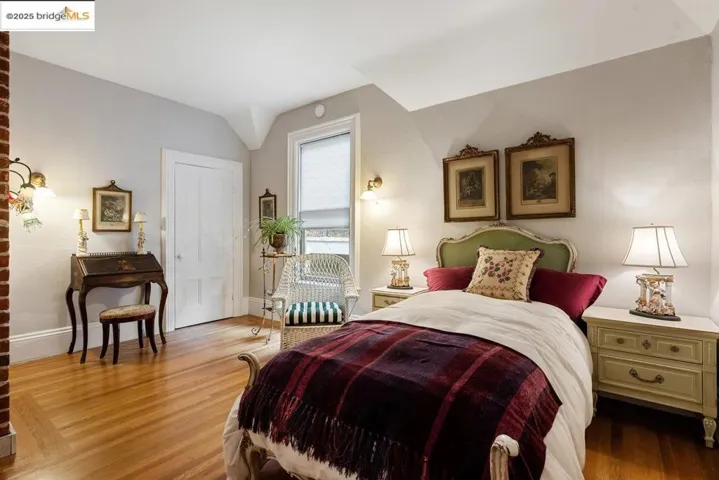 Bedroom with wood finished floors and lofted ceiling