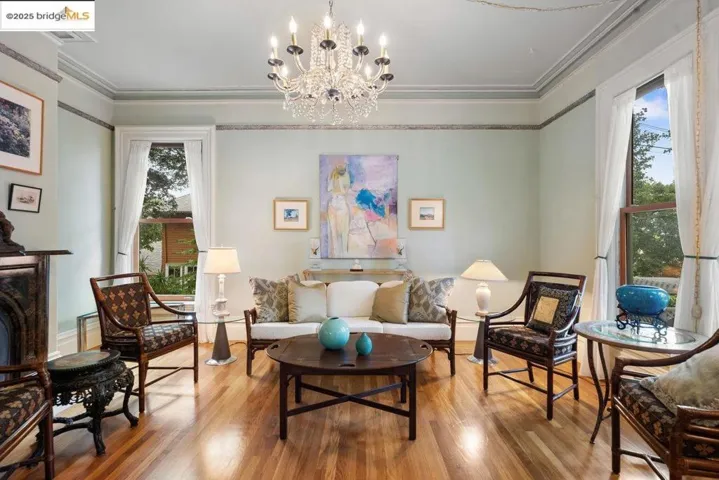 Sitting room featuring ornamental molding, wood finished floors, plenty of natural light, and a chandelier