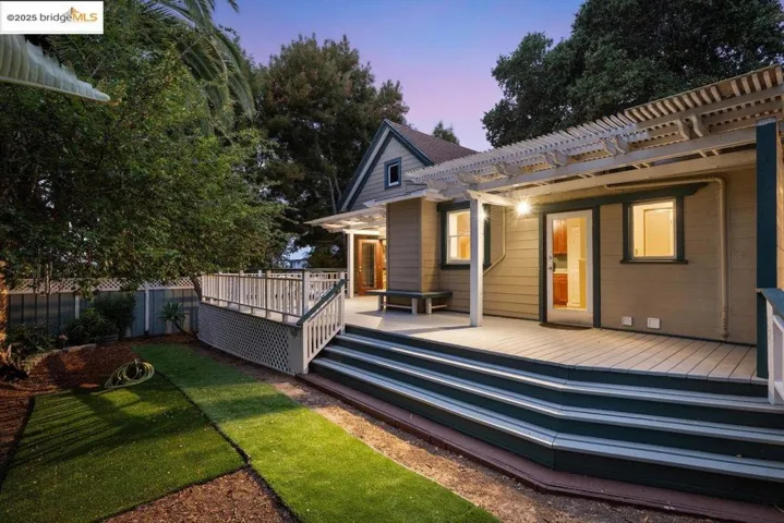 Back of house at dusk with a wooden deck