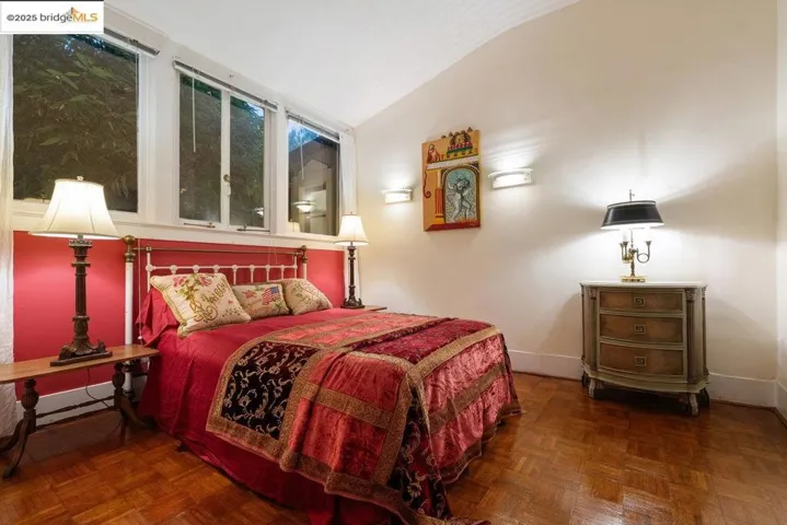 Bedroom featuring lofted ceiling and baseboards