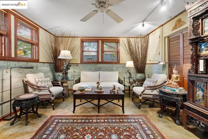 Living area with a ceiling fan and crown molding