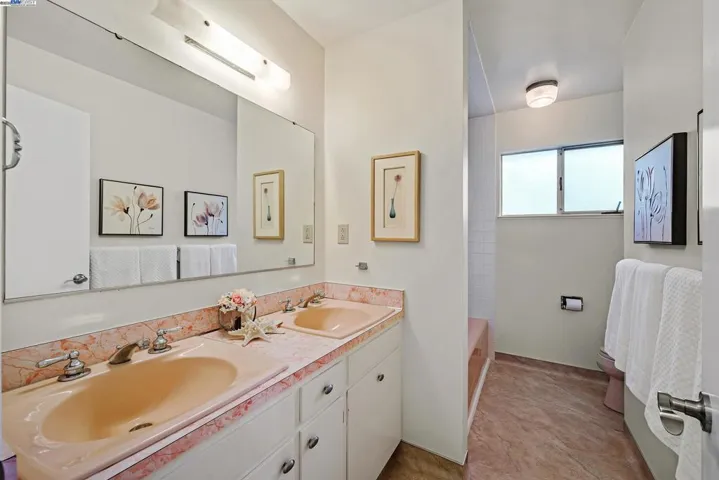 Full bathroom with double sinks, bathtub and shower combination.