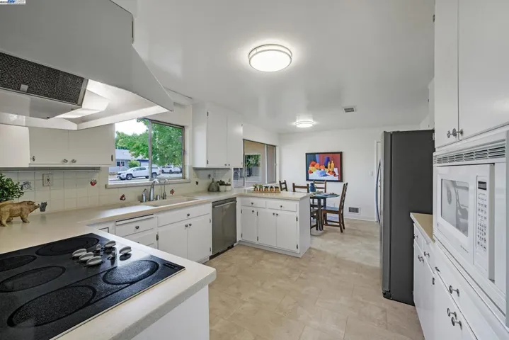 Spacious kitchen with Corian counter tops, dining area, and newer appliances.