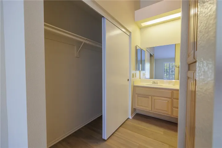 Primary Bathroom Dressing Area with Large Closet and Linen Cabinets