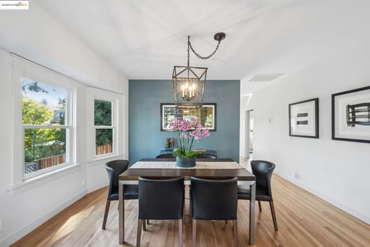 Dining space with wood finished floors and a chandelier