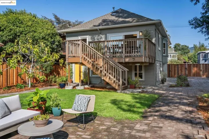 Rear view of house featuring stairs, a patio area, a deck, and roof with shingles