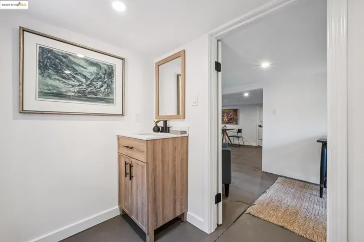 Bathroom featuring finished concrete flooring, vanity, and recessed lighting