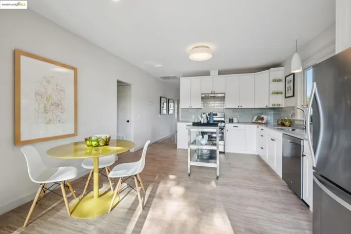Kitchen featuring decorative light fixtures, appliances with stainless steel finishes, decorative backsplash, open shelves, and white cabinetry