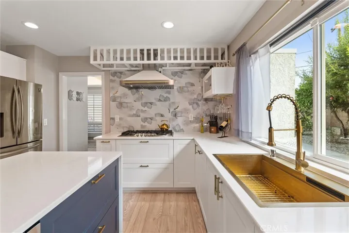 Stylish sink and new 5 burner gas range/hood and backsplash.