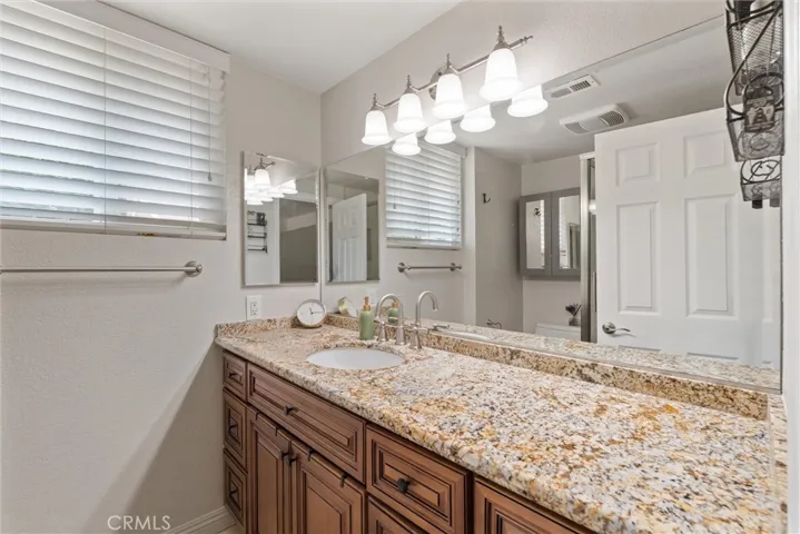 Primary en suite bathroom with beautiful granite countertops.