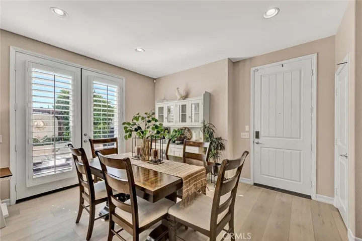 Entry door opens to open concept floorplan with dual pane windows, French doors, plantation shutters and luxury wood vinyl flooring