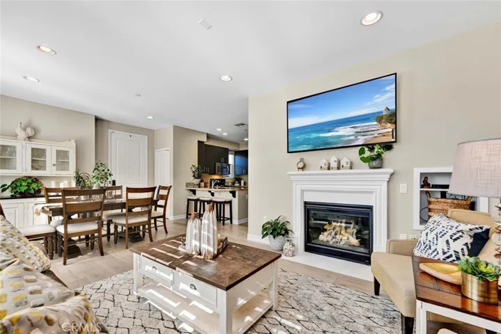Living room with fireplace, dining room, and kitchen