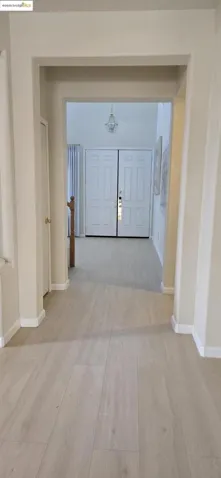 Corridor with light wood-style flooring and baseboards