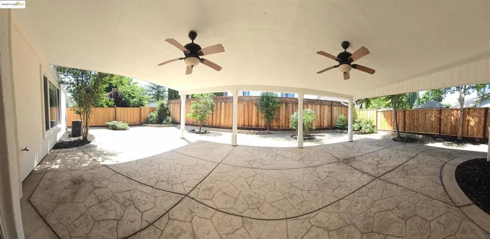 Fenced backyard with a patio and ceiling fan
