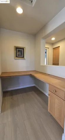 Unfurnished office featuring a textured ceiling, recessed lighting, light wood-style floors, and built in desk