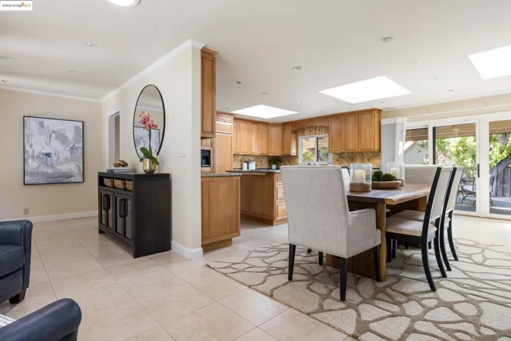 Dining area featuring crown molding, recessed lighting, light tile patterned floors, and a skylight
