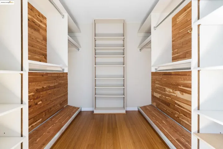 Walk in closet with light wood-style flooring