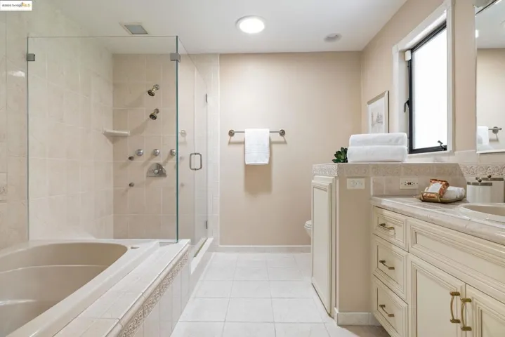 Bathroom featuring vanity, a stall shower, a bath, and light tile patterned floors