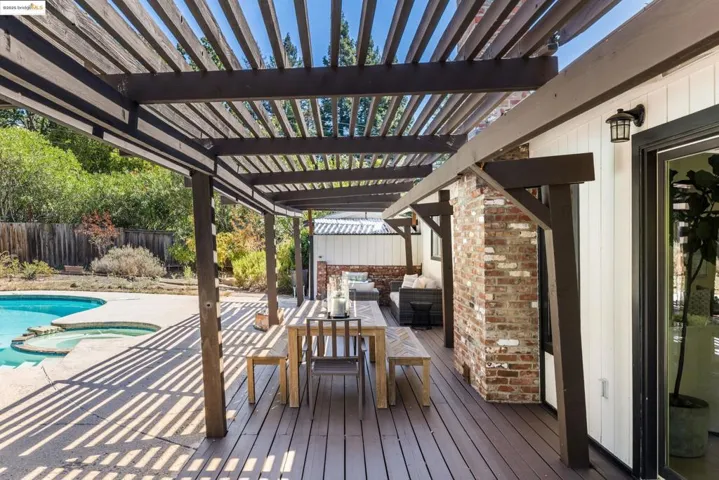 Deck featuring a pool with connected hot tub, outdoor lounge area, a patio area, a pergola, and outdoor dining area