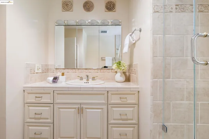 Full bath featuring vanity, tasteful backsplash, and a stall shower